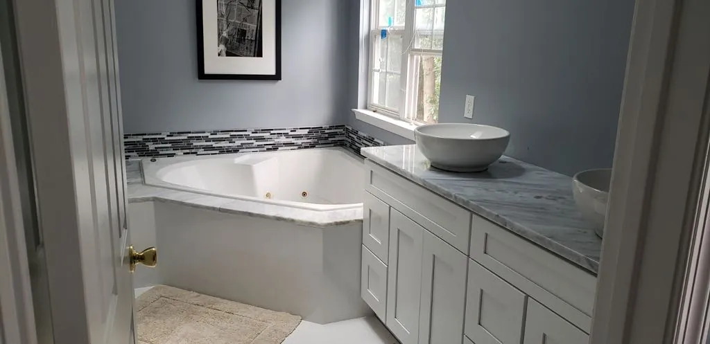 Bathroom with granite vanity and corner tub