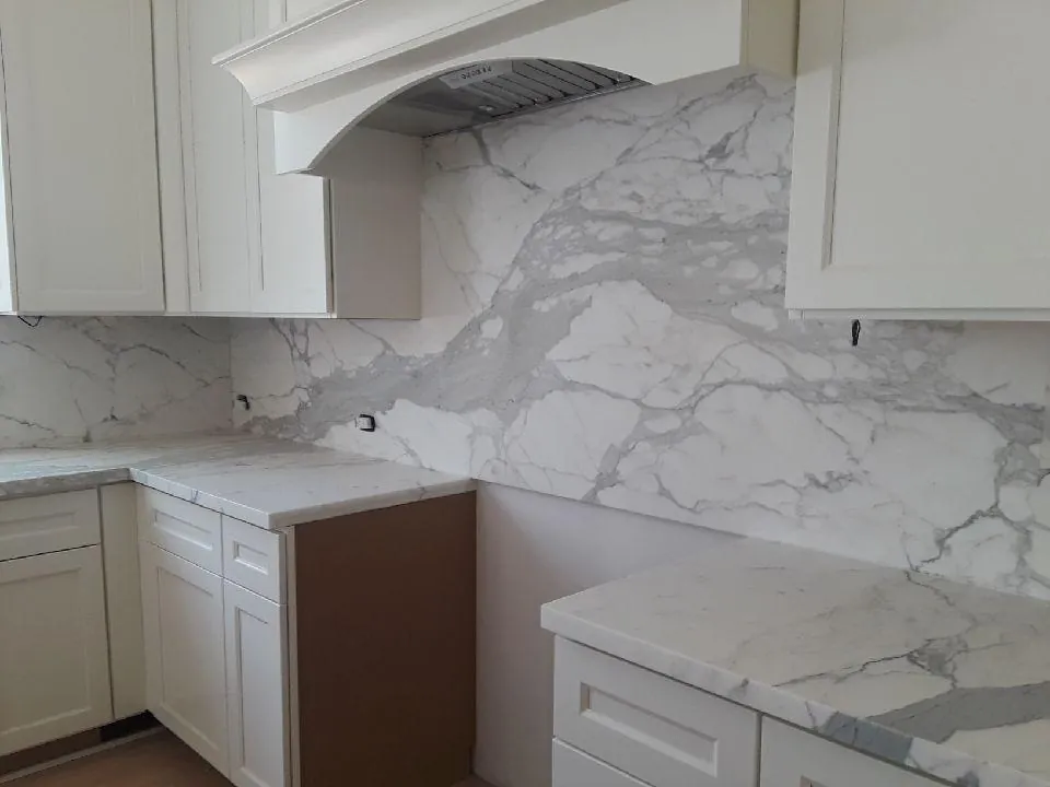 Full-slab Calacatta backsplash behind range hood